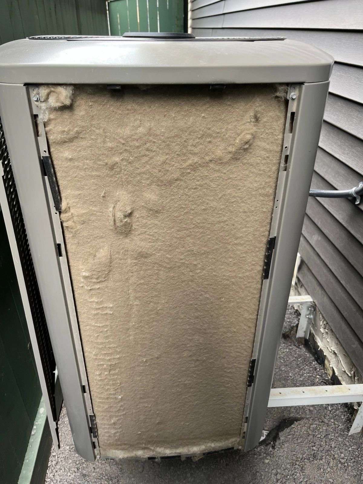 Dirty exterior condenser coil packed with debris before A/C cleaning