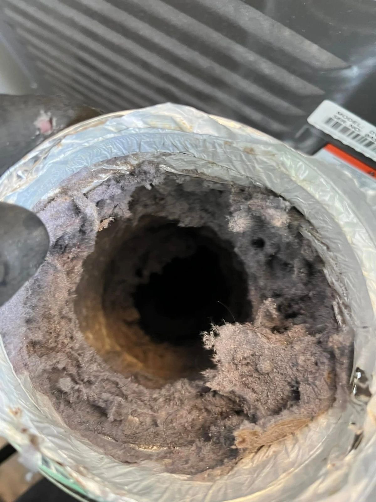 Main-floor dryer vent line packed with lint before cleaning