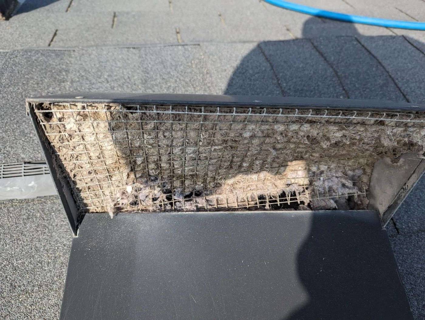 Second-story roof dryer vent cap packed with lint before cleaning