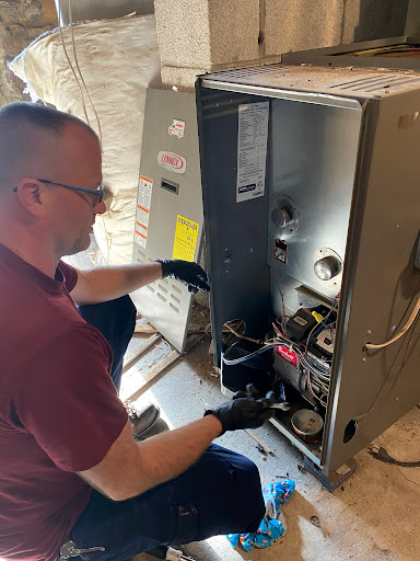 Aurora technician servicing an open furnace